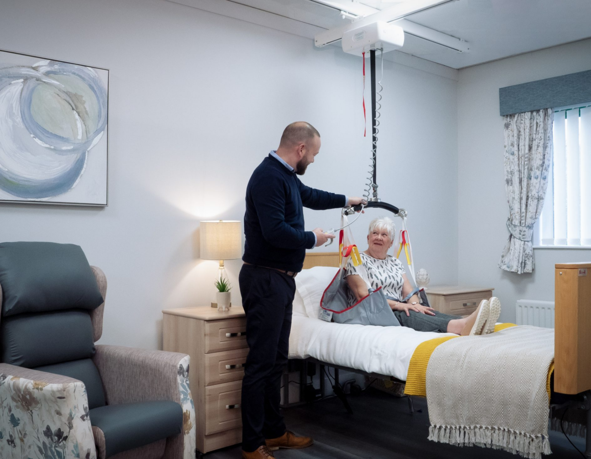 caretaker looking at the patient lift for their loved one